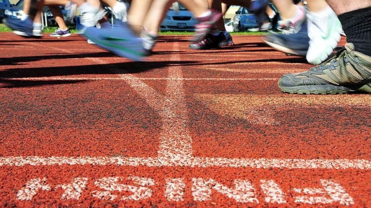 People's feet crossing a finish line.