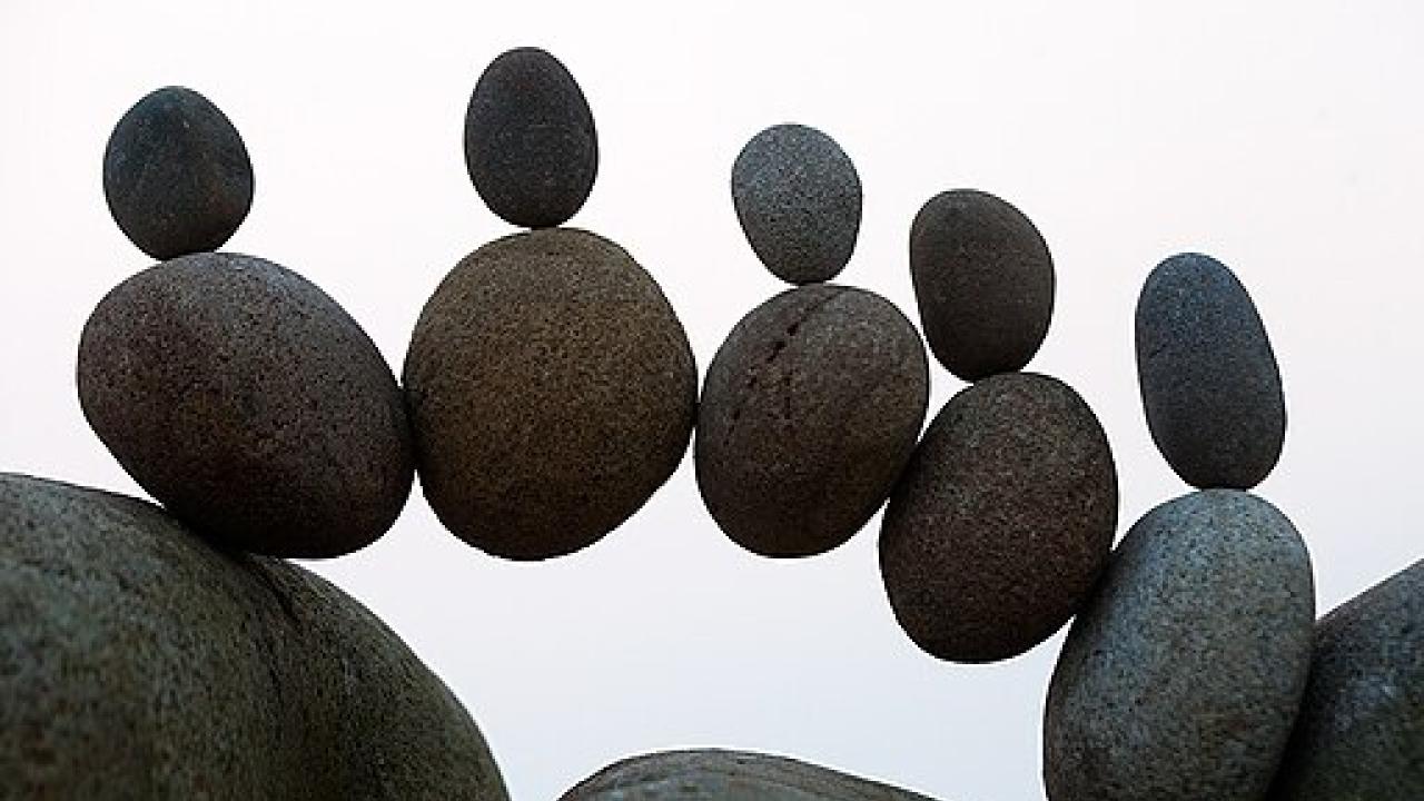 Rows of rocks balanced between two boulders.