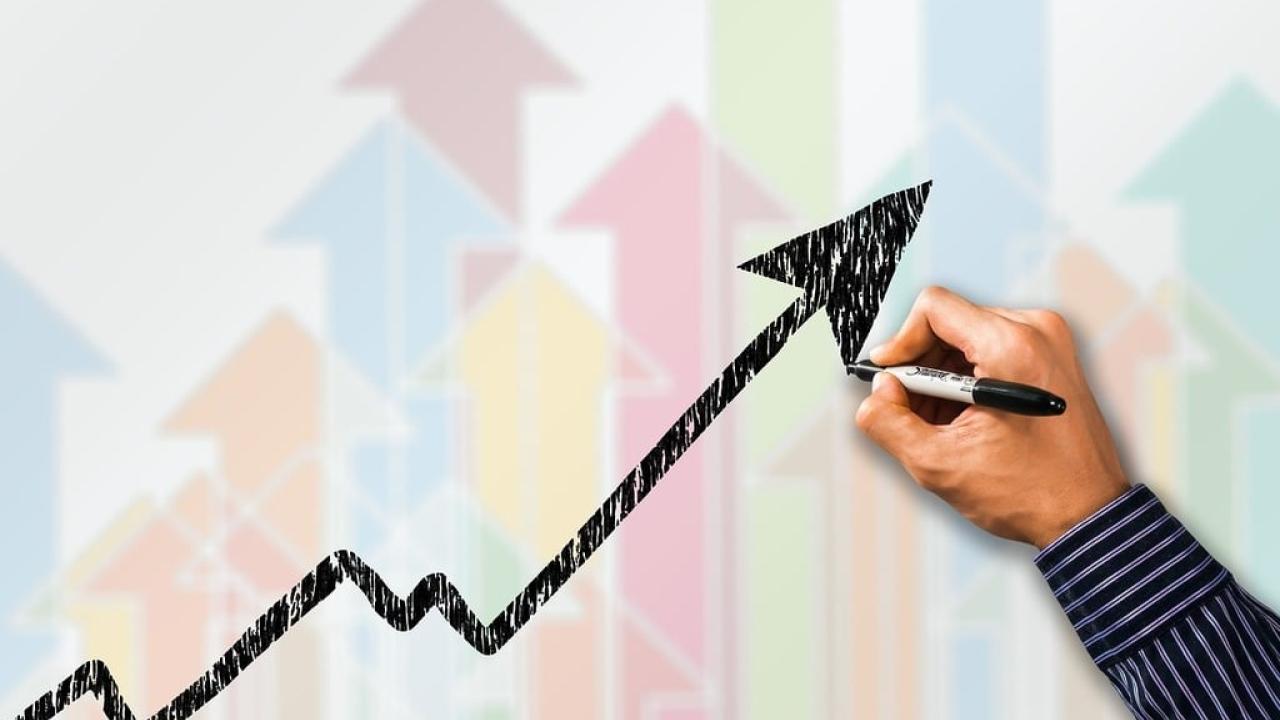 Person's hand drawing a graph.
