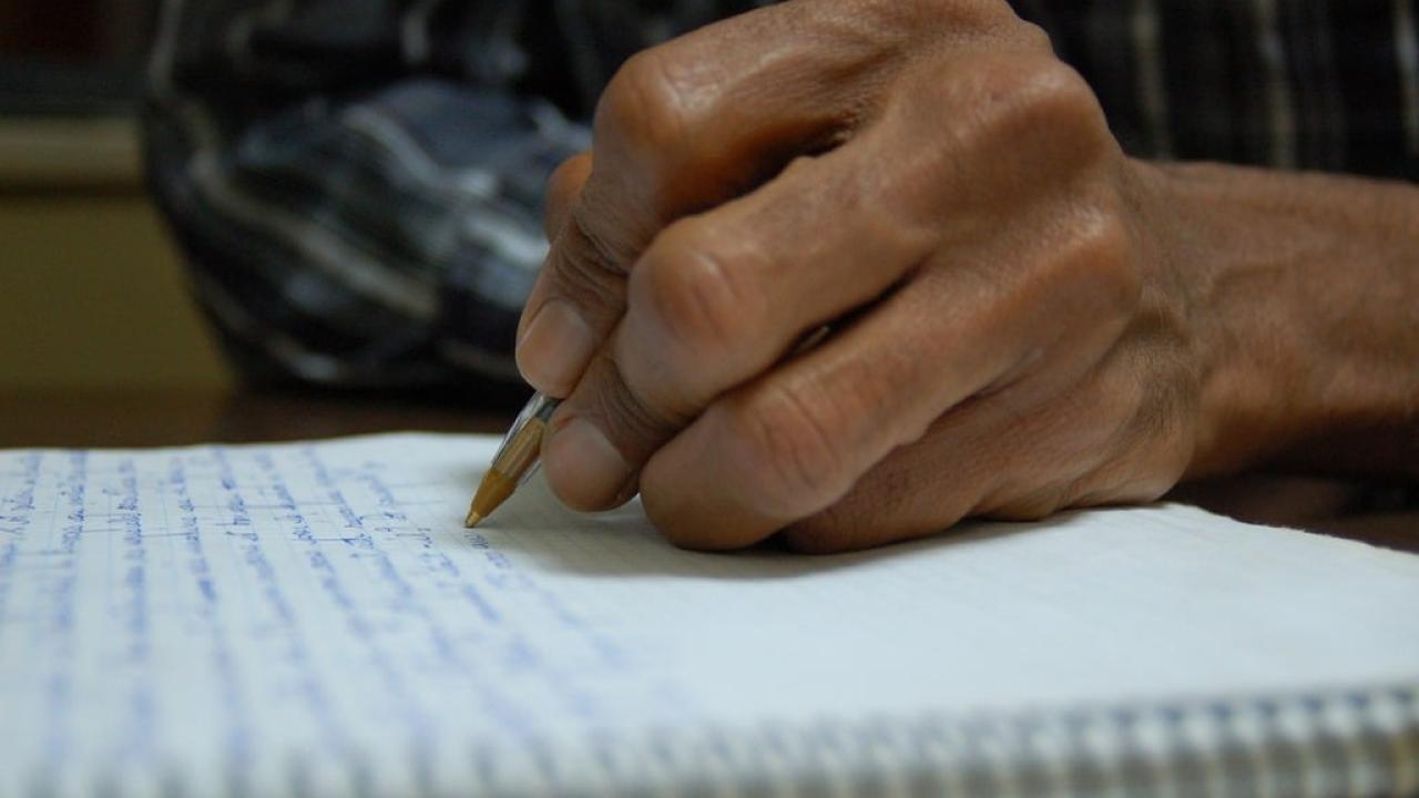 Person's hand with pen and paper