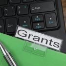 Keyboard overlaid with file folder with a Grants label