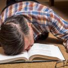 Man asleep with face in a book.